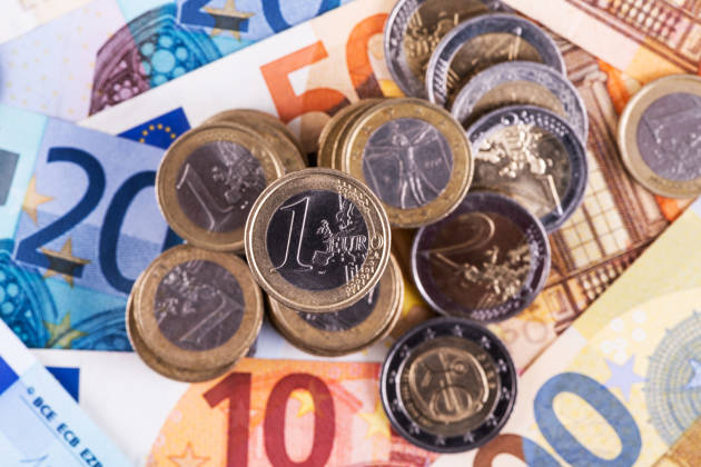 Euromunten 1 en 2 euro bovenop eurobiljetten van verschillende waardes